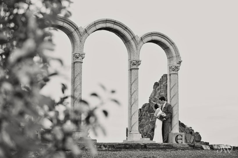 bride and groom pose beneath arches captured by Tara Whittaker Photography