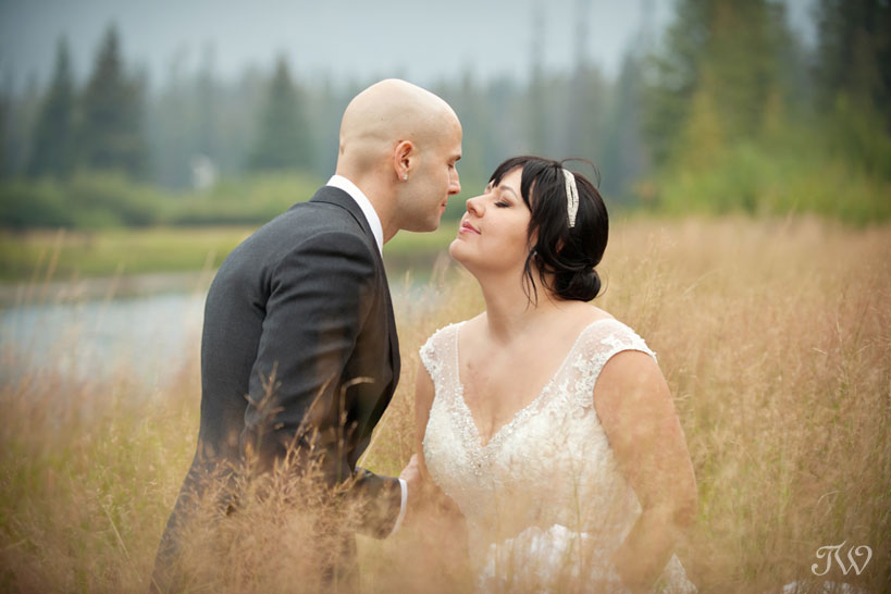 bride and groom by the Bow River in the Town of Banff captured by Tara Whittaker Photography