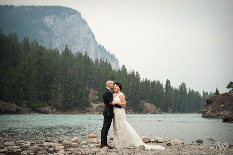bride and groom by the Bow River in Banff captured by Tara Whittaker Photography