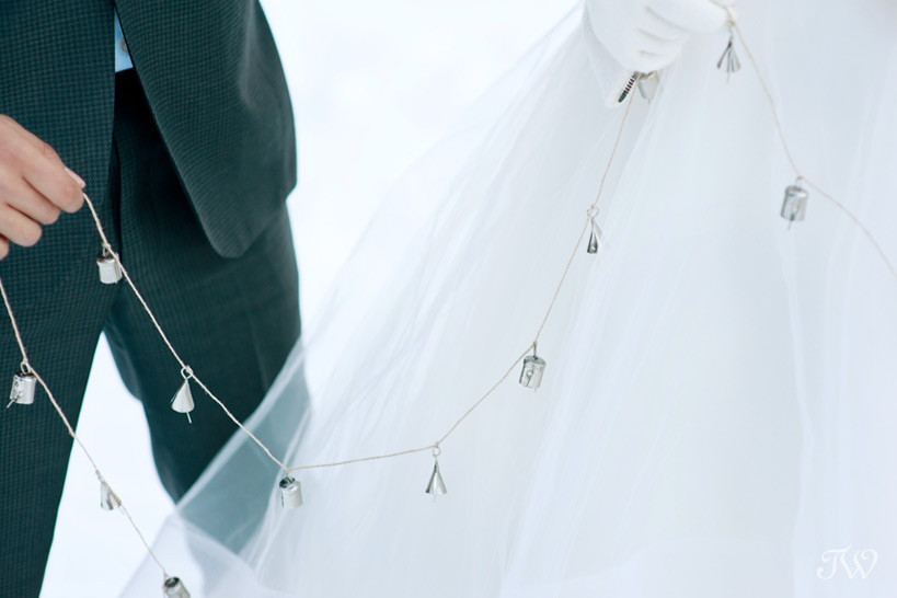 bride and groom hold silver bells captured by Tara Whittaker Photography