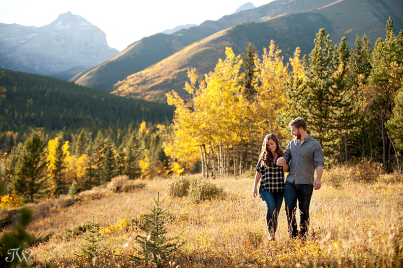 couple walk in the Rocky Mountains during their fall engagement session captured by Tara Whittaker Photography