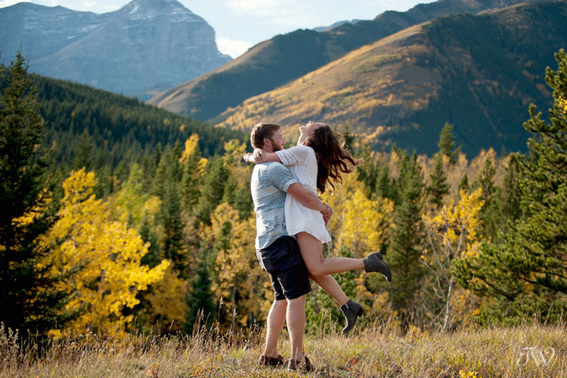 groom twirls the bride during their mountain engagement session in Kananaskis