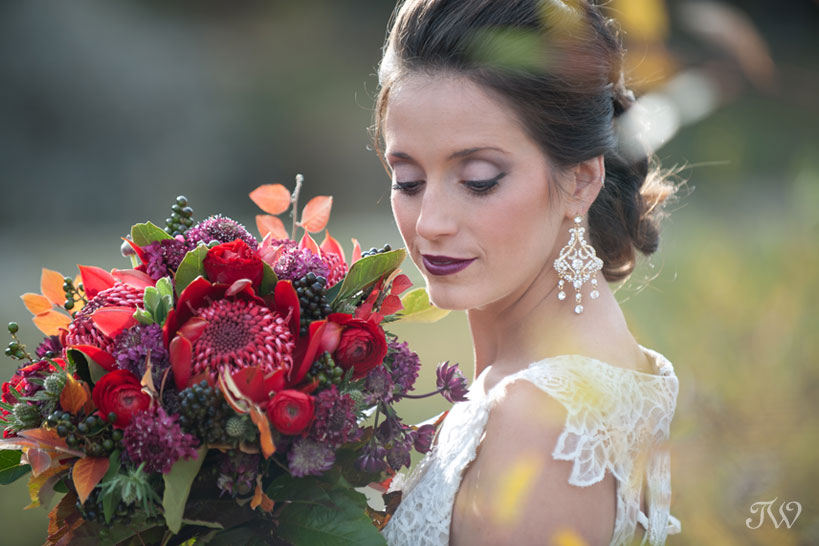 autumn bride carries a bouquet of protea captured by Calgary wedding photographer Tara Whittaker