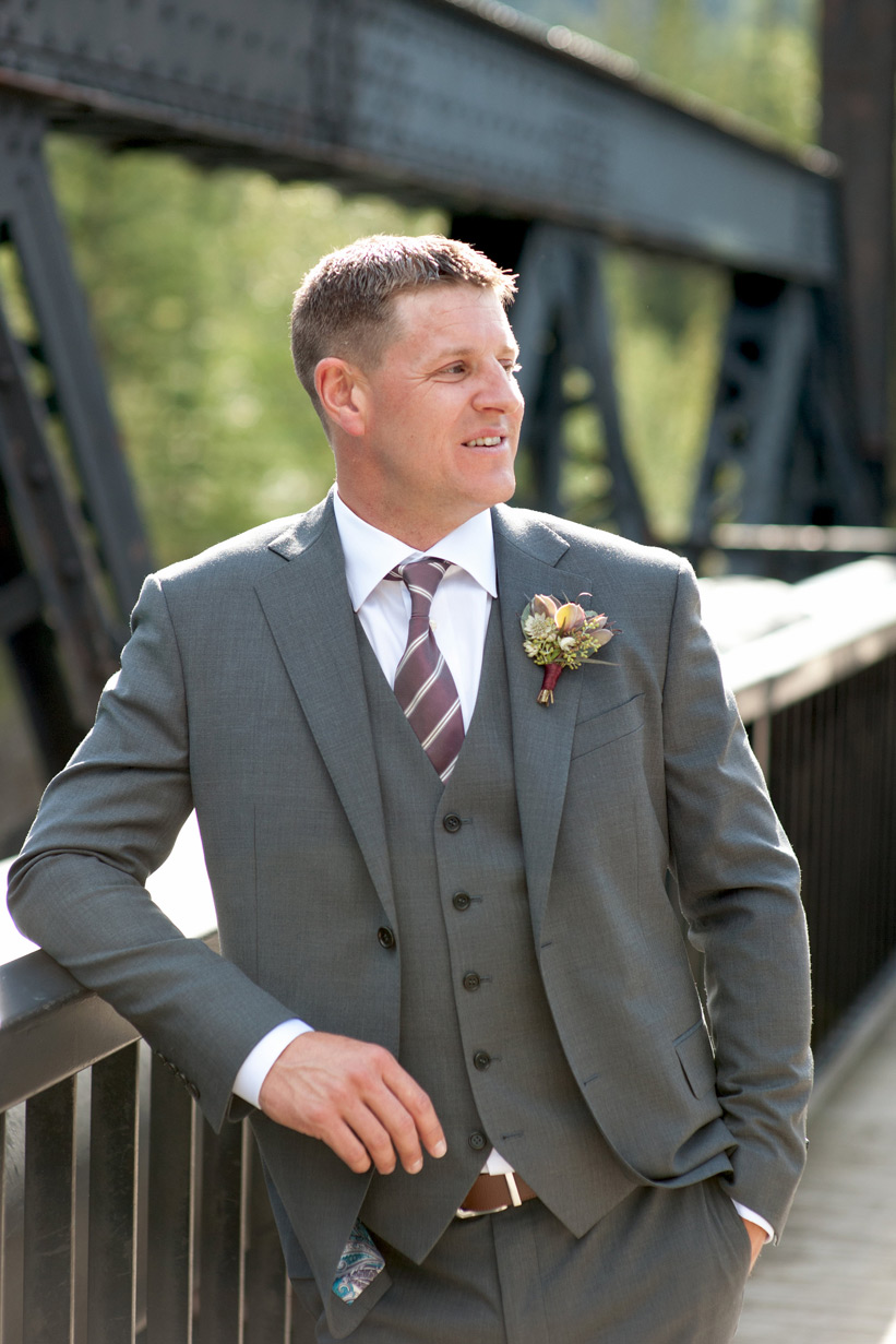 groom on the railway bridge in Canmore captured by Tara Whittaker Photography