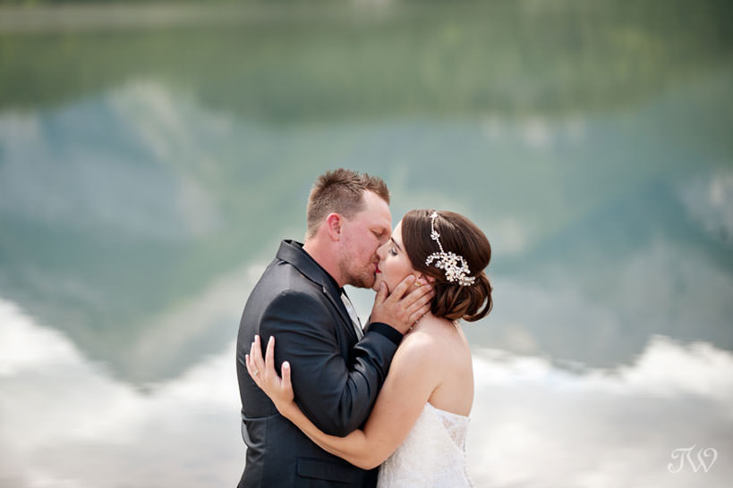 First kiss on the shore of Barrier Lake captured by Calgary wedding photographer Tara Whittaker 