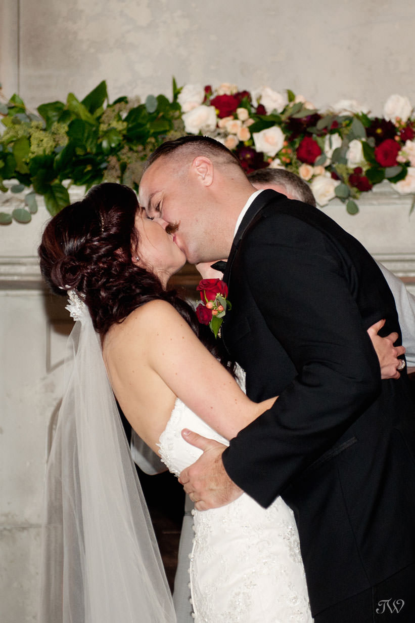 first kiss at a Lake House wedding captured by Calgary wedding photographer Tara Whittaker