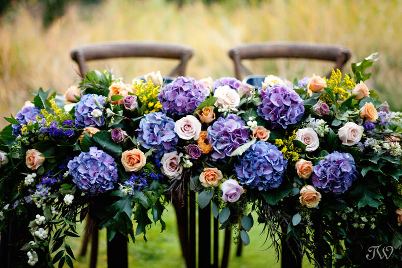flowers adorn a sweet table at a Silvertip wedding captured by Calgary wedding photographer Tara Whittaker