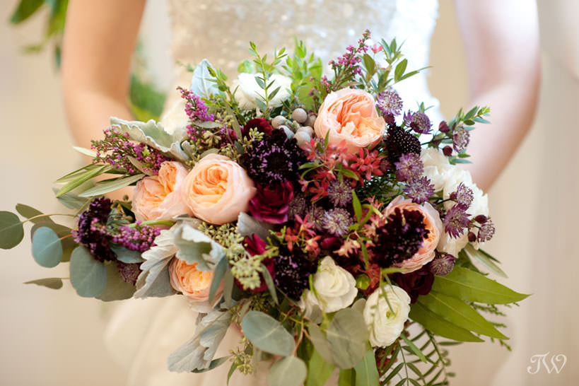 winter bride carries a bouquet in berry tones captured by Calgary wedding photographer Tara Whittaker