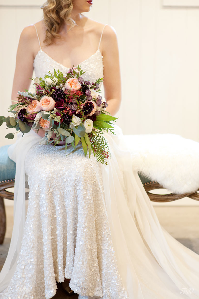 winter bride carries a bouquet in berry tones captured by Calgary wedding photographer Tara Whittaker