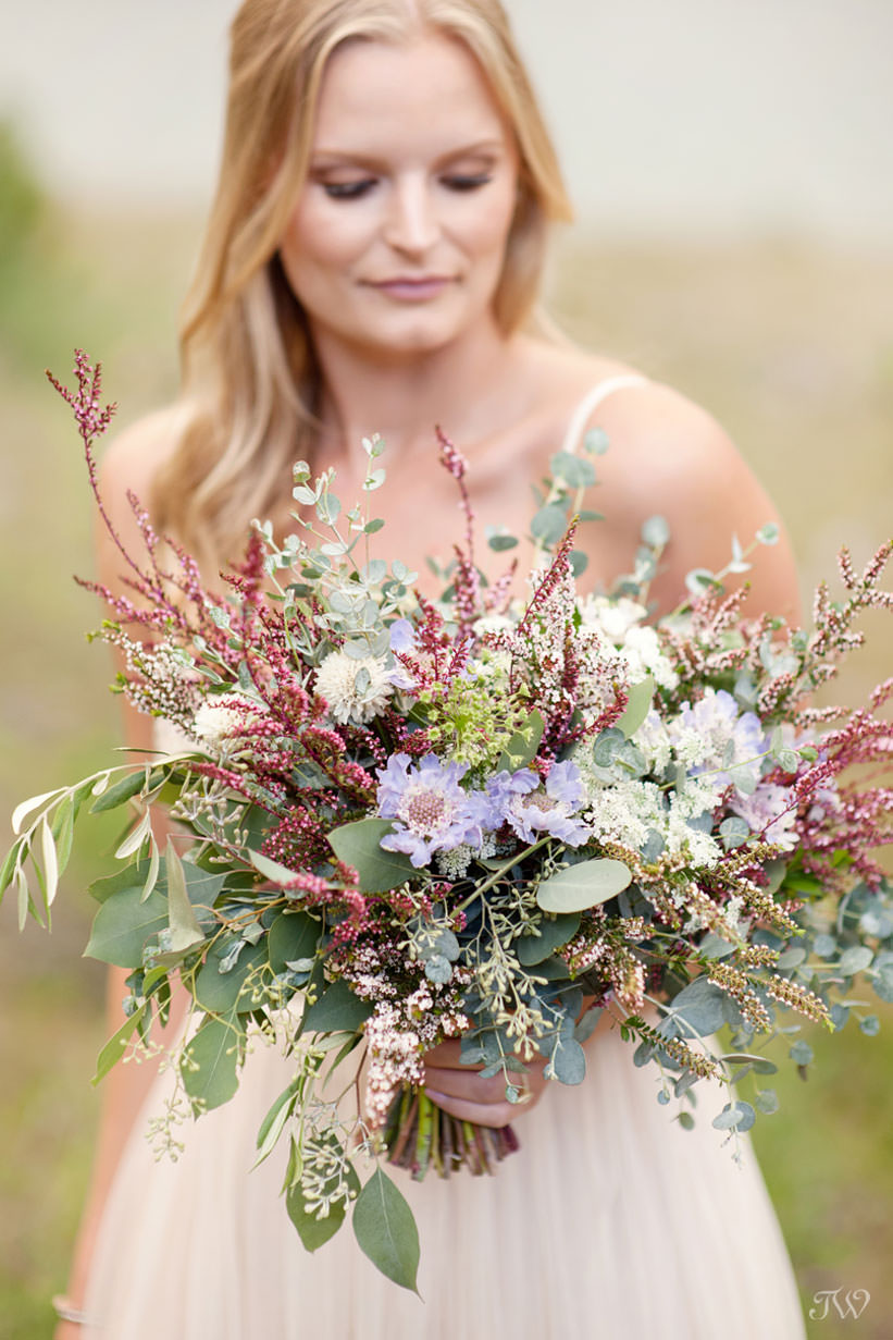 Caitie carries a wildflowers bouquet at her Spray Lakes engagement session captured by Tara Whittaker Photography