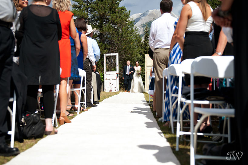 Canmore bride walks down the aisle with her Dad captured by Tara Whittaker Photography