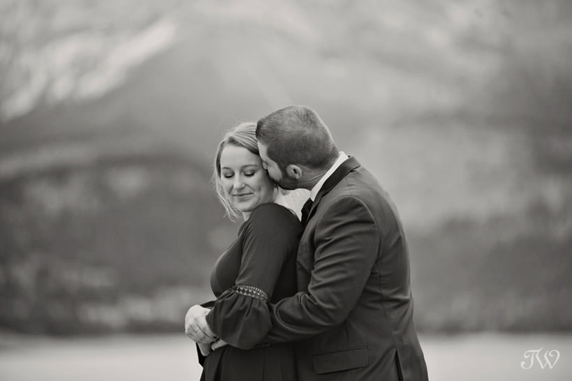 bride and groom embrace on the shore of Barrier Lake in Kananaskis captured by Tara Whittaker Photography