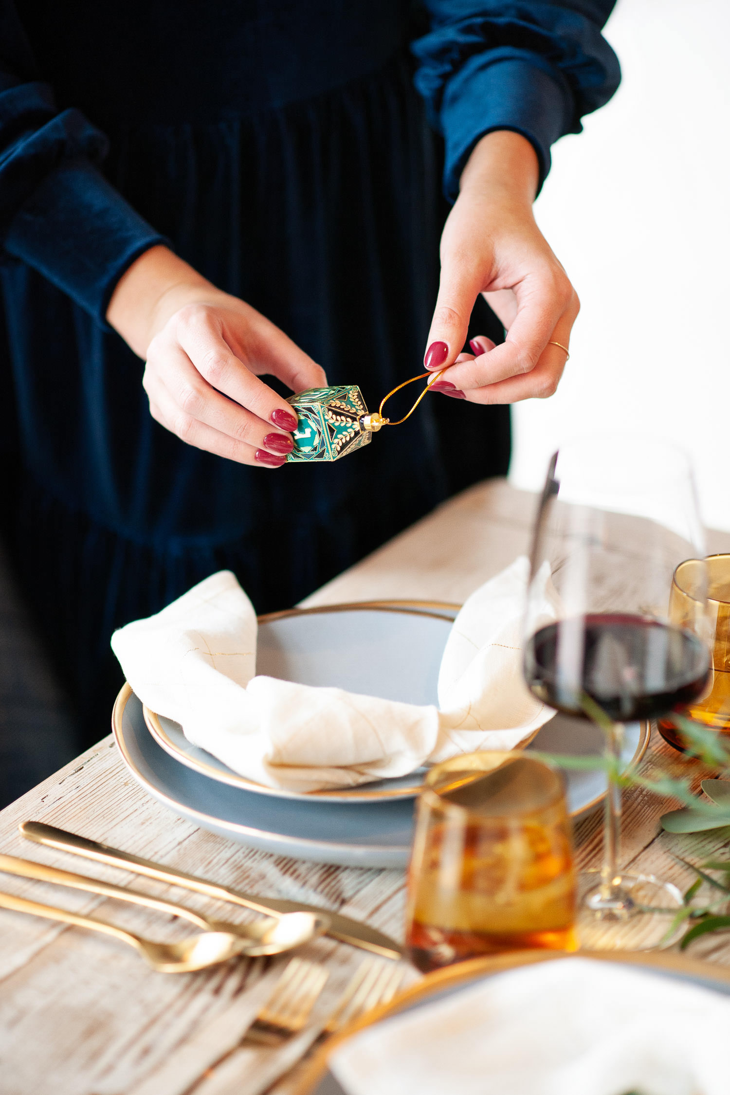 Evelyn from 206 Event Co. places dreidels on Hanukkah table captured by Tara Whittaker Photography