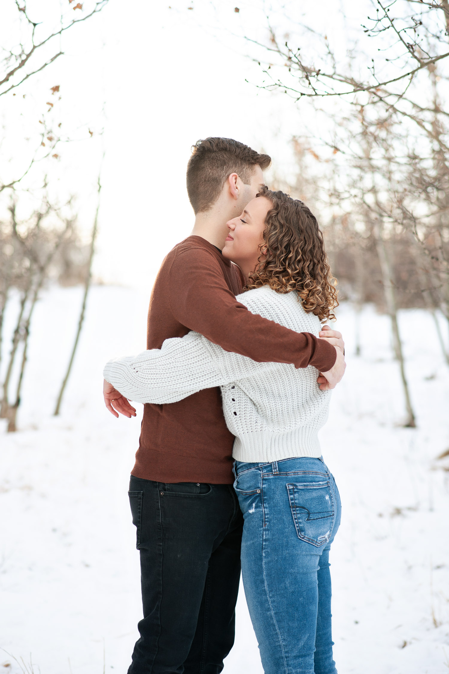 couple hug during their winter engagement session captured by Tara Whittaker Photography