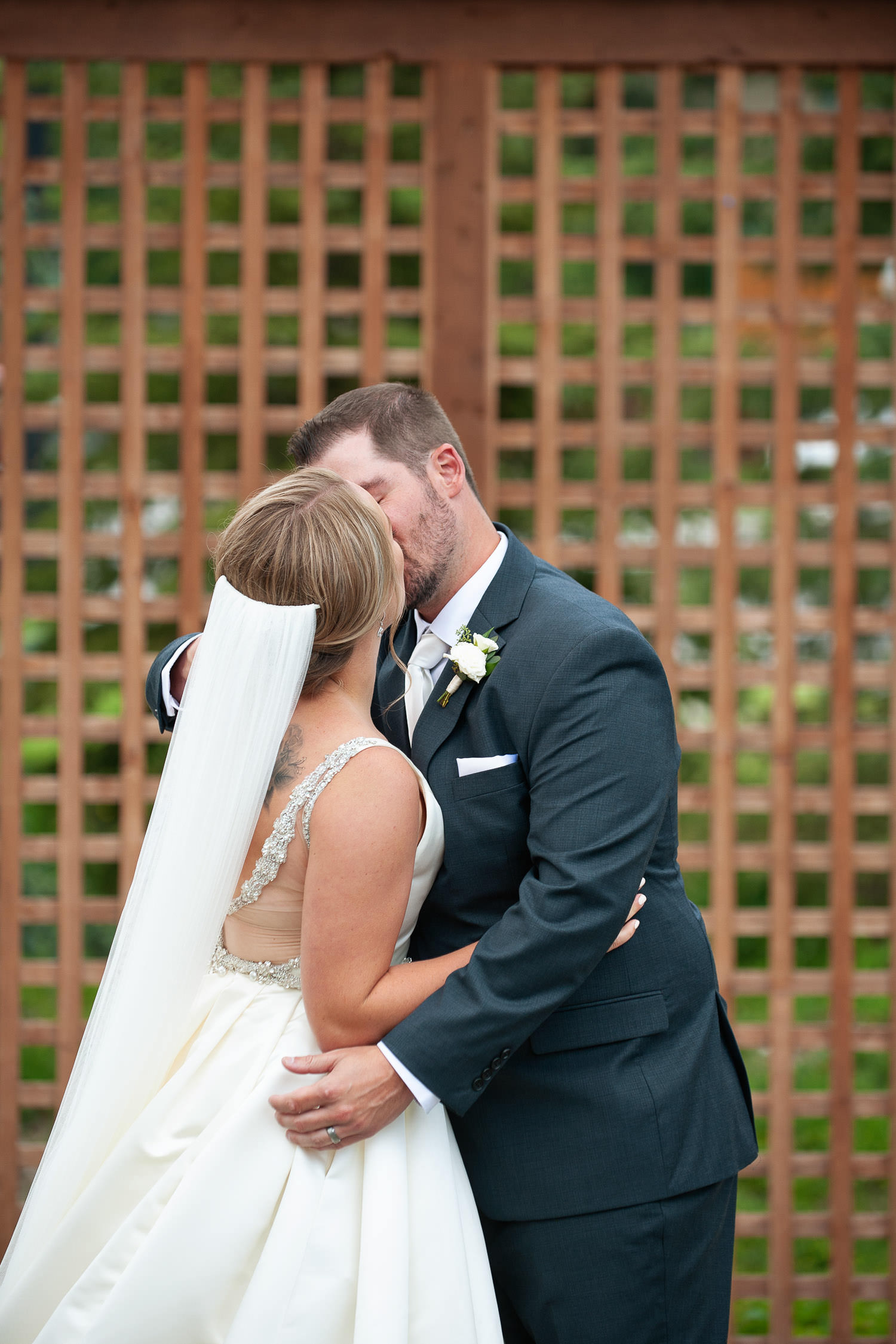 First kiss after a Creekside Villa wedding captured by Canmore wedding photographer Tara Whittaker