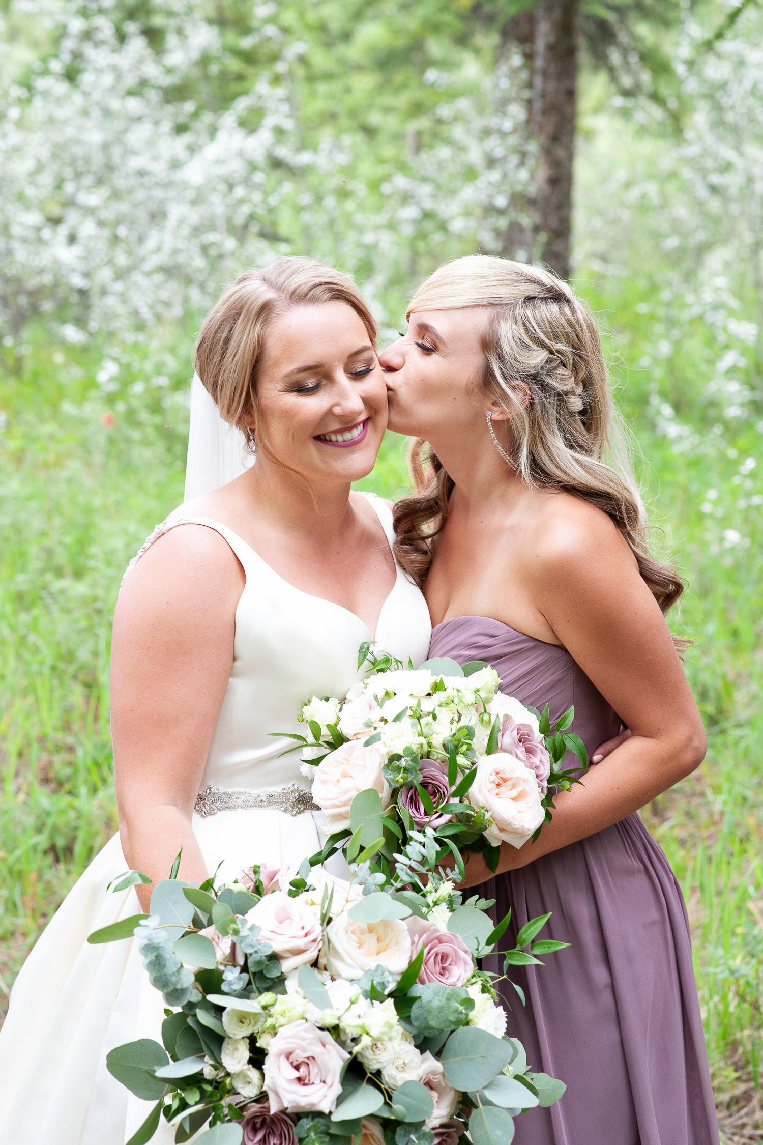 Bride with her bridesmaid captured by Canmore wedding photographer Tara Whittaker