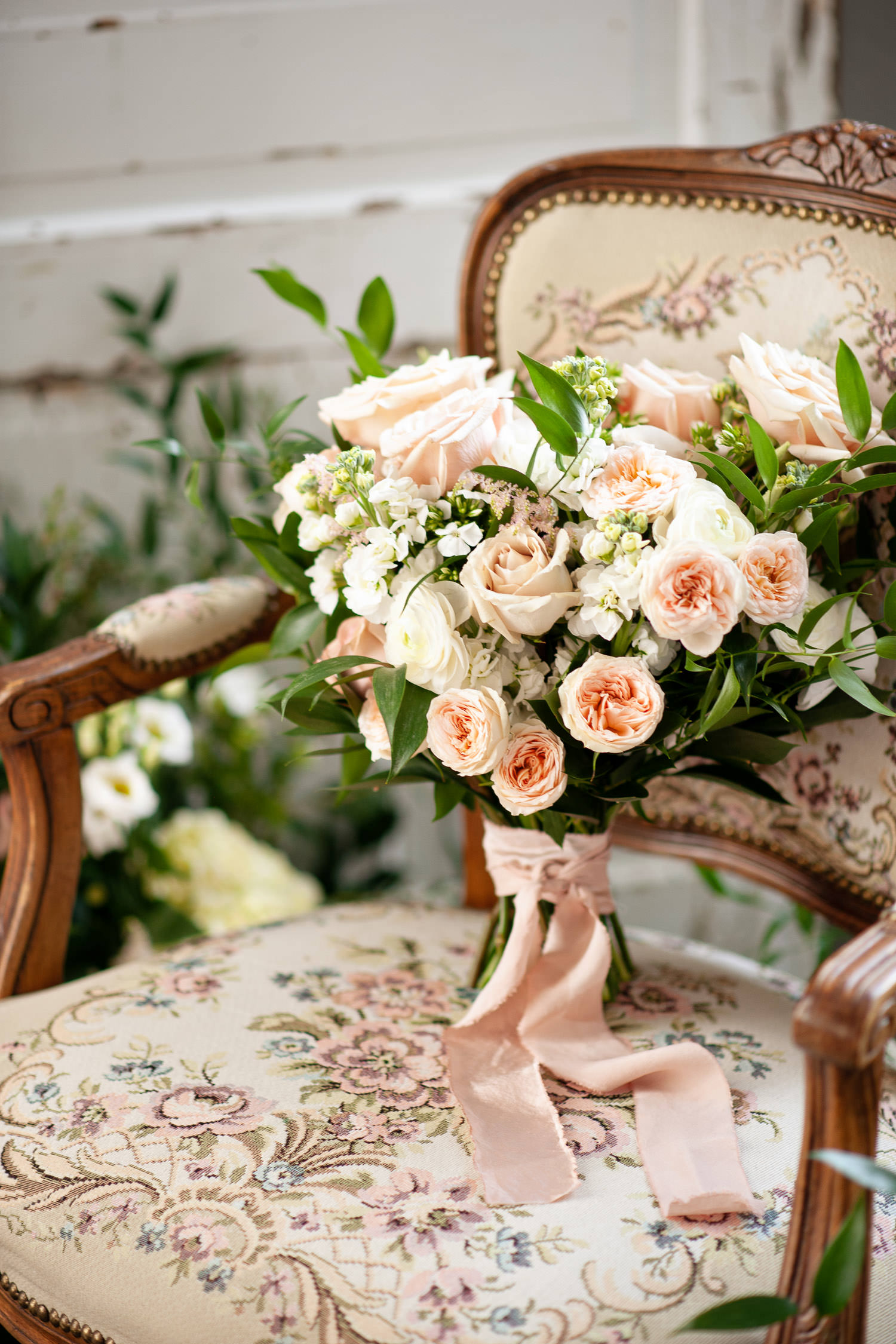 bridal bouquet sits on a vintage chair captured by Tara Whittaker Photography