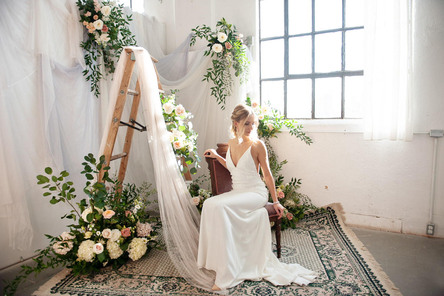 bride seated with flowers and vintage ladder captured by Tara Whittaker Photography