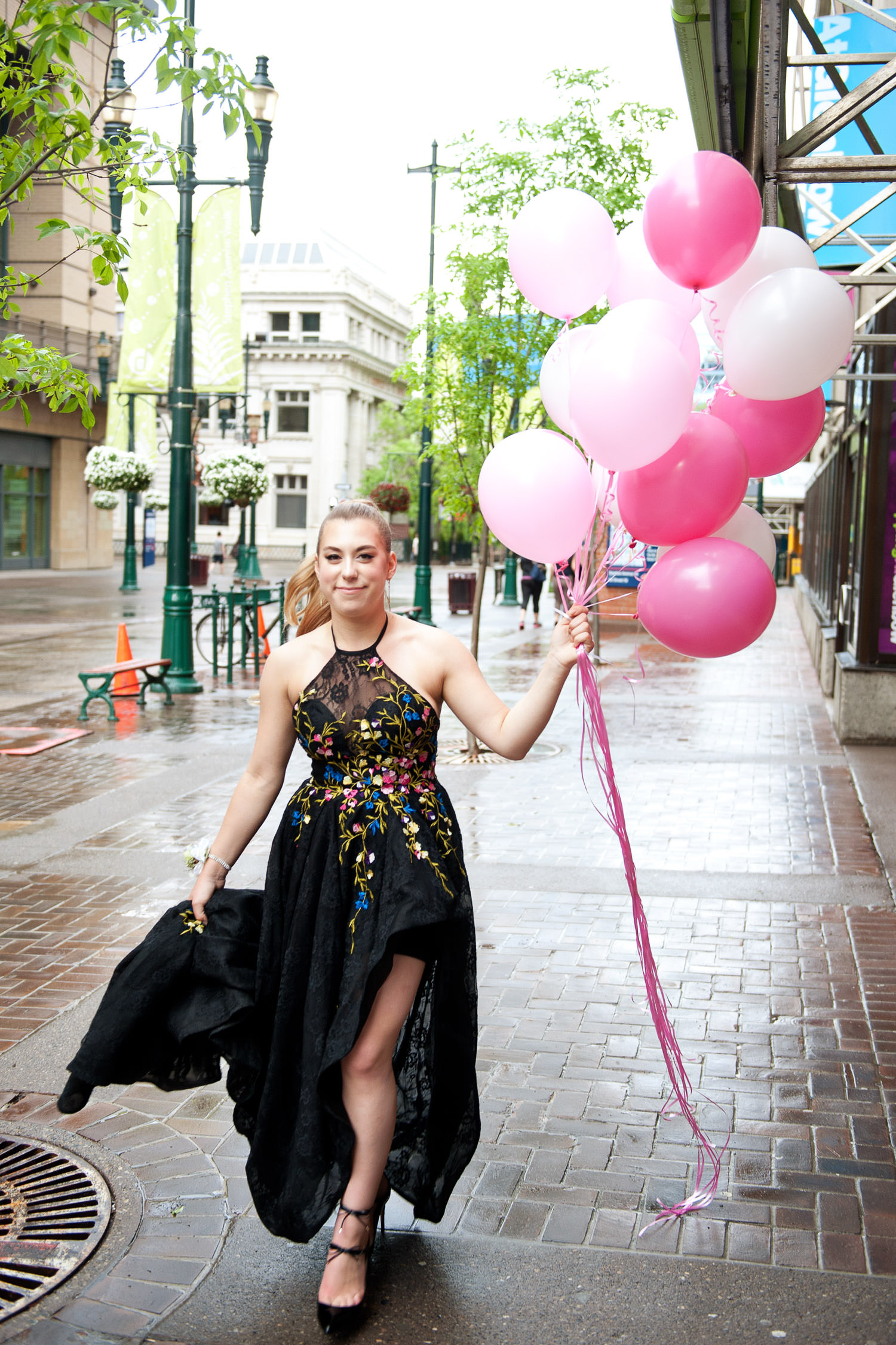 graduate carrying pink balloons on the way to her grad captured by Tara Whittaker Photography