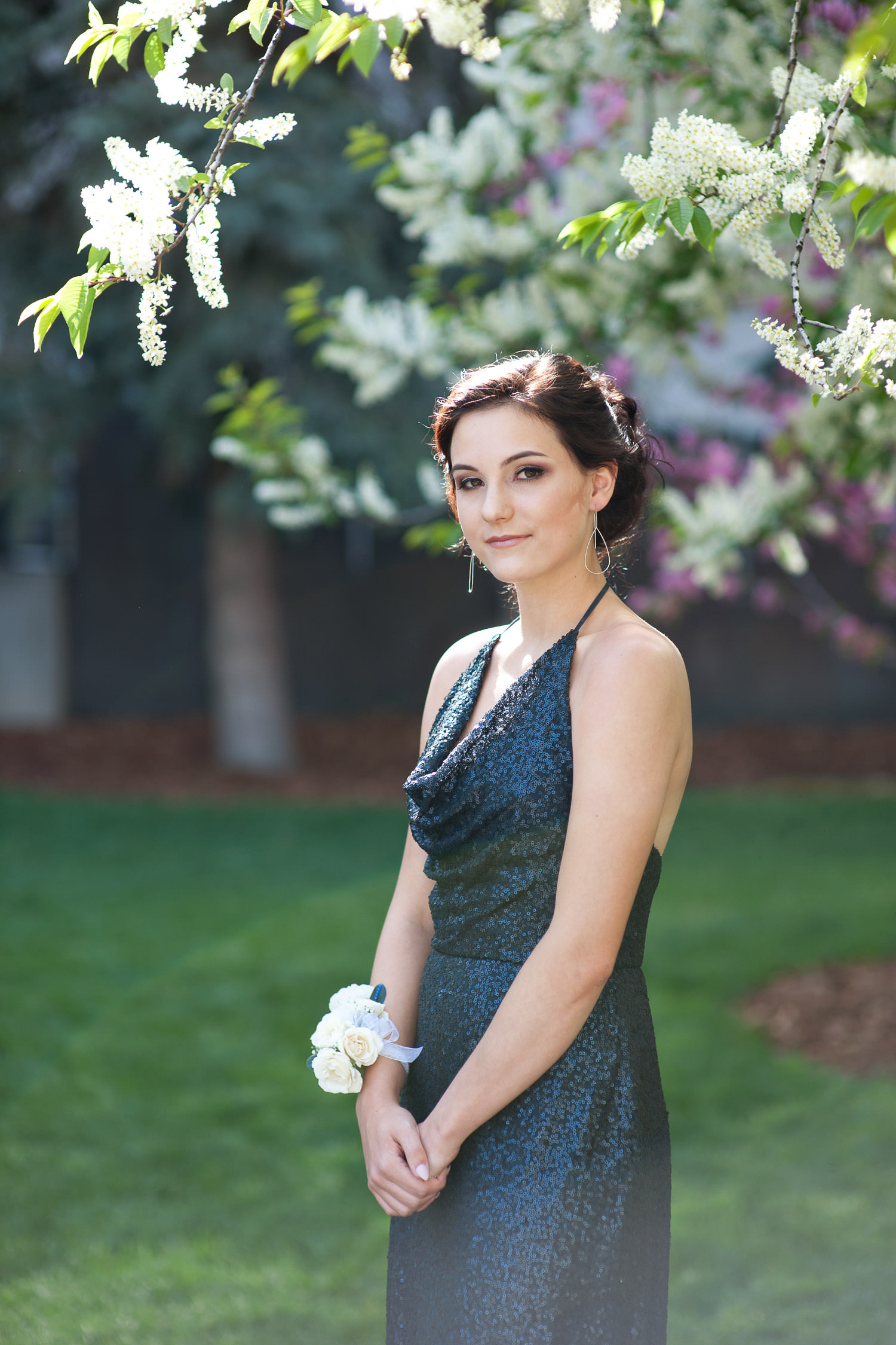 graduate poses with a blossoming tree captured by Tara Whittaker Photography