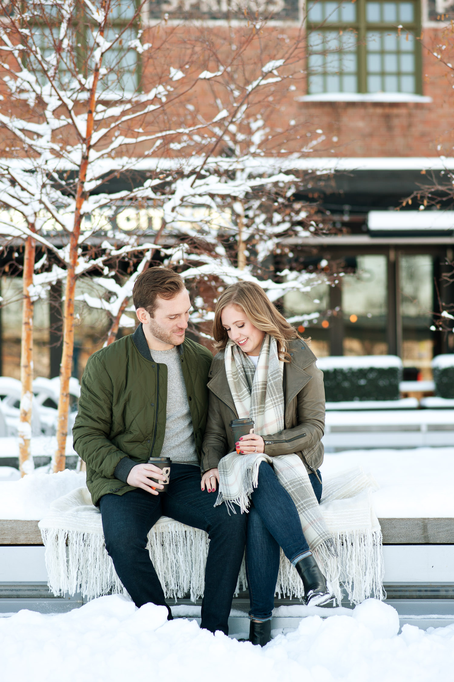 Couple share at hot coffee at their winter engagement session captured by Tara Whittaker Photography