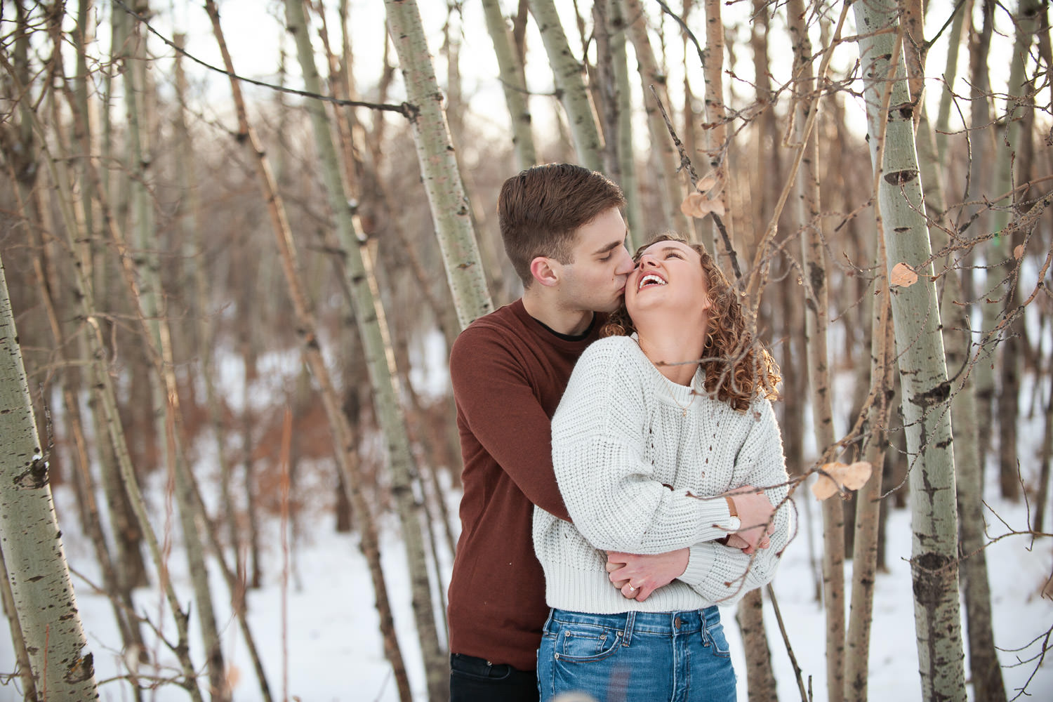 Couple embrace during a winter engagement at Edworthy Park captured by Tara Whittaker