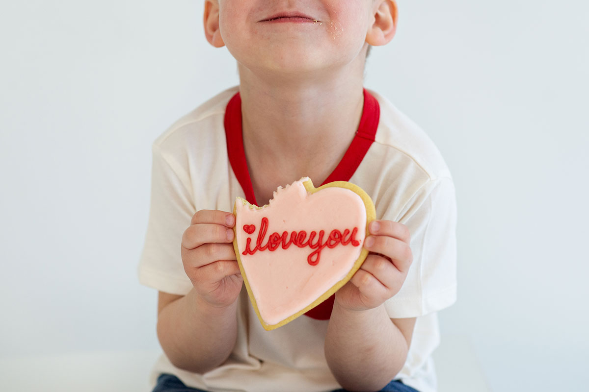 Child with a Valentine's Day cookie from Crave Calgary